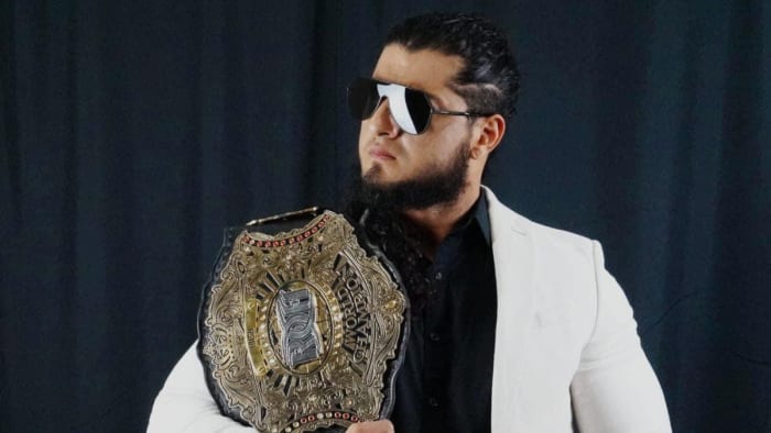 Ring of Honor champion Rush poses with his title